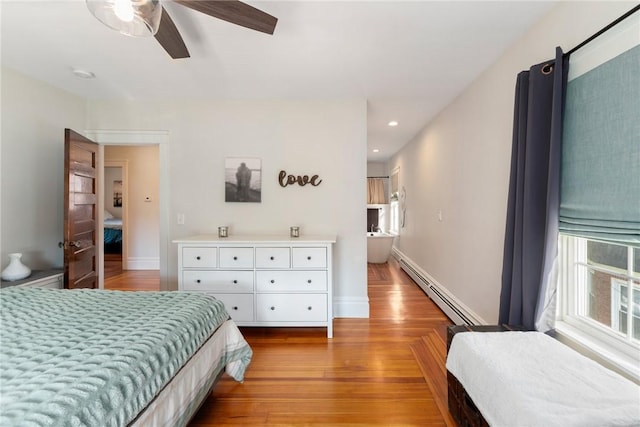 bedroom with a baseboard radiator, ceiling fan, and light wood-type flooring