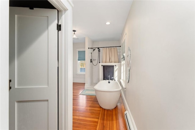 bathroom featuring hardwood / wood-style flooring and plus walk in shower