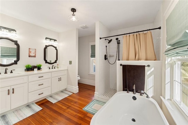 bathroom with wood-type flooring, separate shower and tub, and vanity