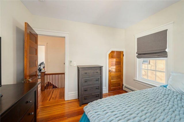 bedroom featuring a baseboard radiator and light hardwood / wood-style flooring