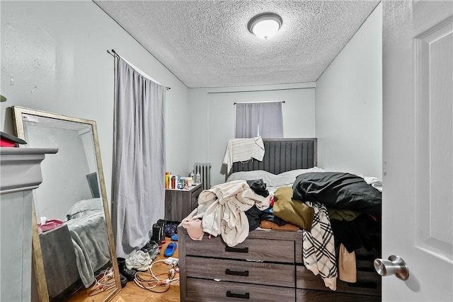 bedroom with hardwood / wood-style flooring and a textured ceiling