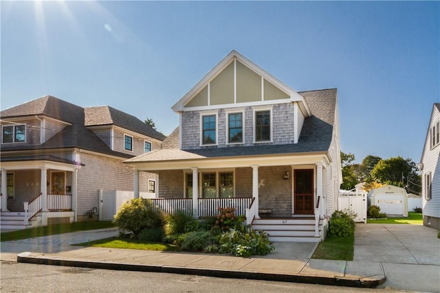 view of front of property featuring a garage, an outdoor structure, and a porch