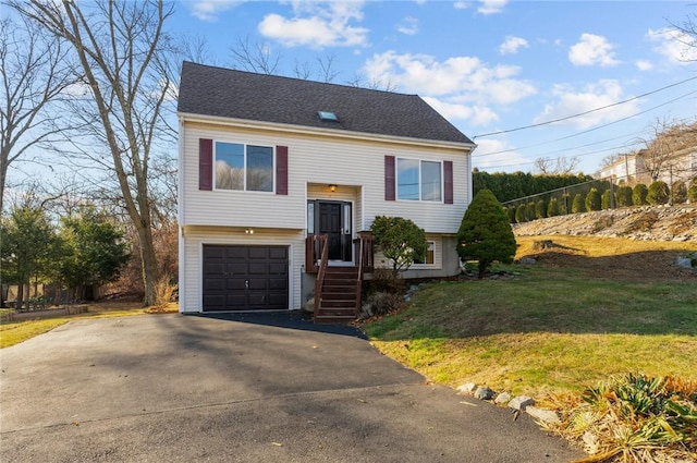 split foyer home featuring a garage and a front yard