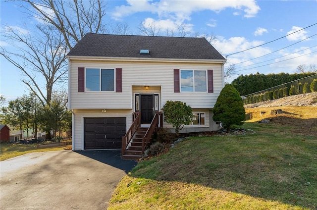 split foyer home with a garage and a front yard