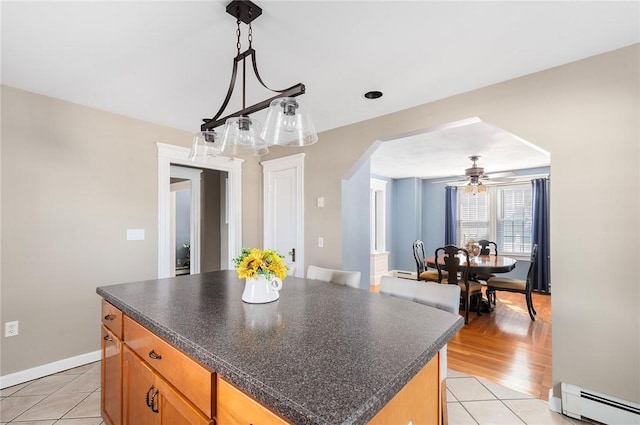 kitchen featuring a baseboard heating unit, decorative light fixtures, light tile patterned floors, and a kitchen island