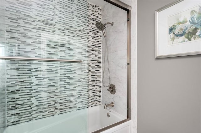 bathroom with bath / shower combo with glass door