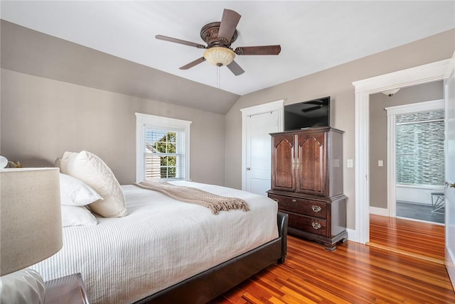 bedroom with hardwood / wood-style flooring, vaulted ceiling, and ceiling fan