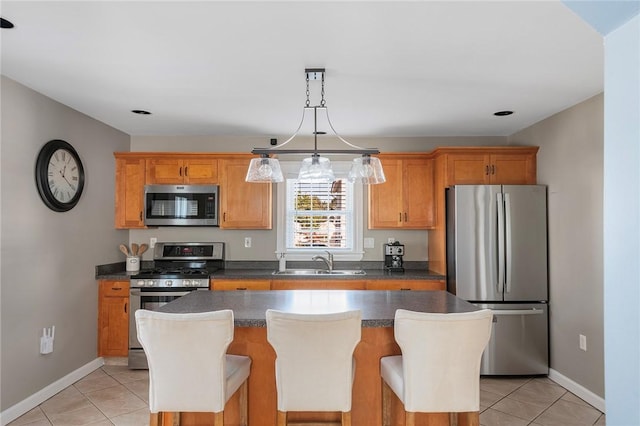 kitchen with sink, light tile patterned flooring, stainless steel appliances, and a kitchen island