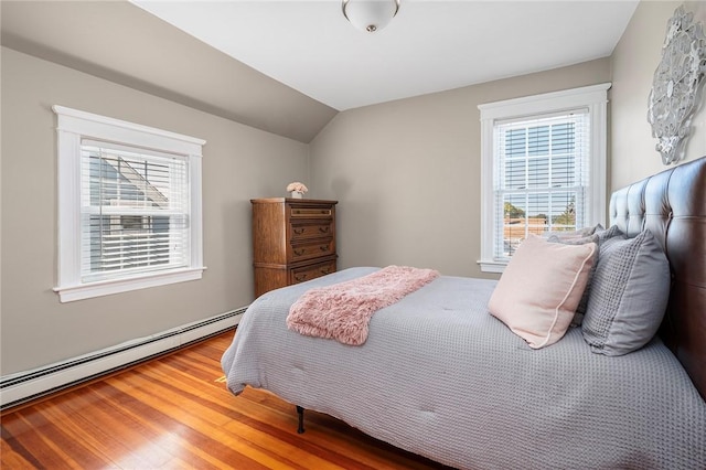 bedroom with wood-type flooring, lofted ceiling, and a baseboard heating unit