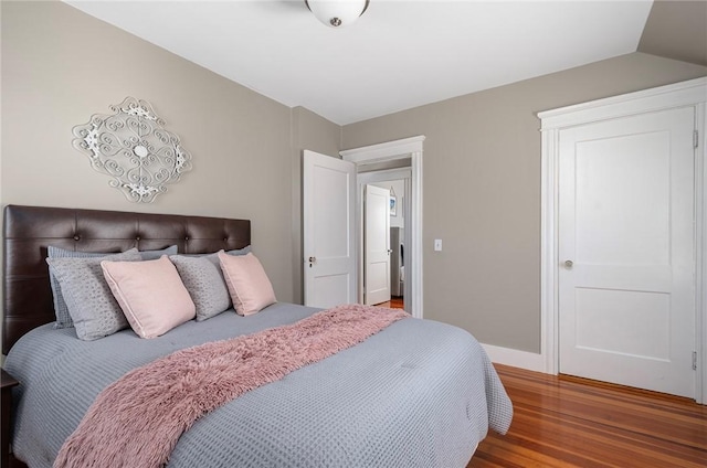 bedroom with wood-type flooring and vaulted ceiling