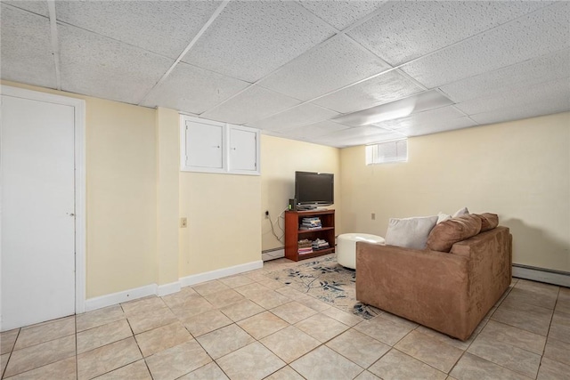 unfurnished living room with light tile patterned flooring, a baseboard radiator, and a paneled ceiling