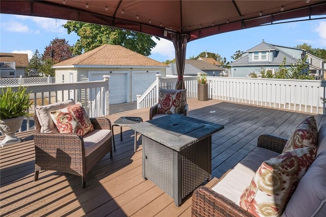 wooden deck with an outbuilding, a garage, a gazebo, and outdoor lounge area