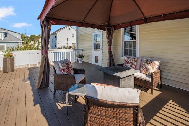 wooden deck with a gazebo and an outdoor living space with a fire pit