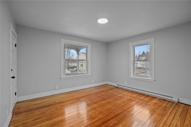 unfurnished room featuring hardwood / wood-style flooring and a baseboard radiator