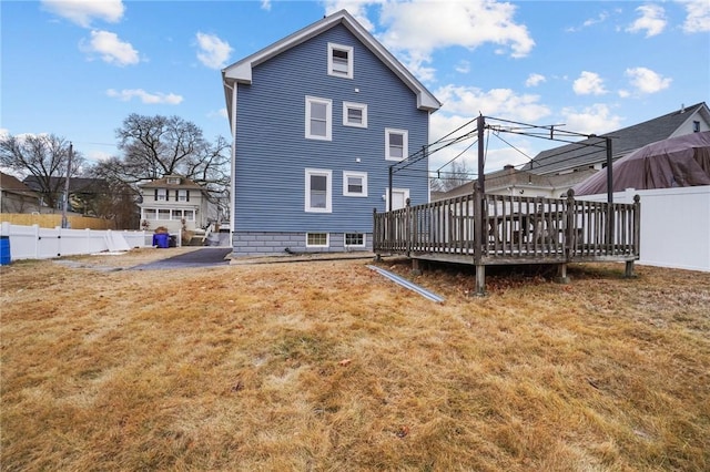 rear view of property featuring a wooden deck and a yard