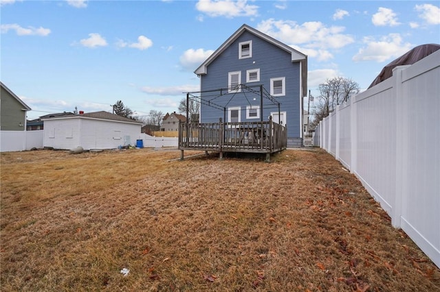 back of property featuring a gazebo, a wooden deck, and a lawn