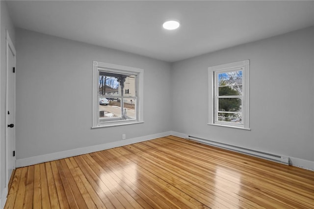 empty room with a baseboard radiator and light wood-type flooring