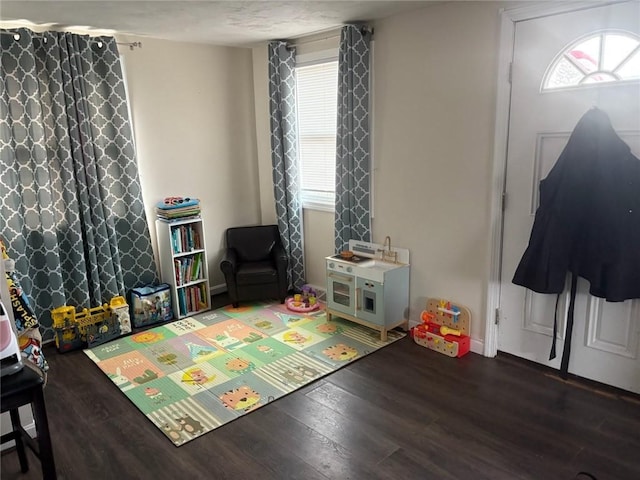 game room with a healthy amount of sunlight and dark hardwood / wood-style floors