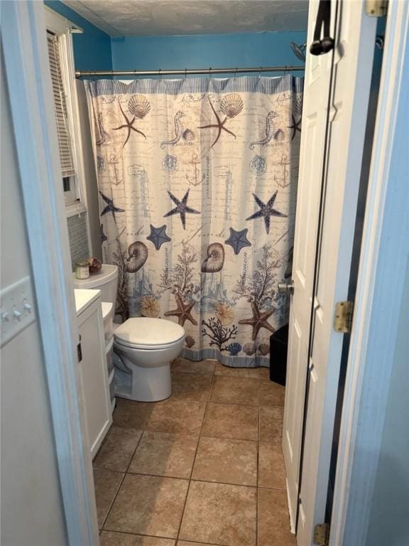 bathroom with curtained shower, tile patterned flooring, vanity, toilet, and a textured ceiling