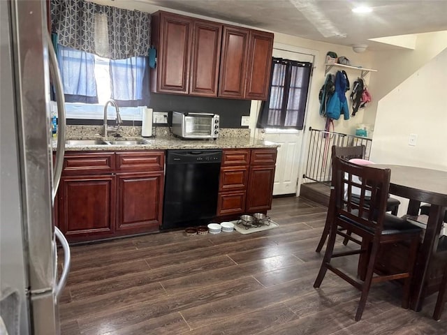 kitchen with sink, dark hardwood / wood-style flooring, stainless steel fridge, dishwasher, and light stone countertops