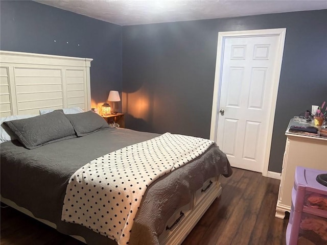 bedroom with dark hardwood / wood-style flooring