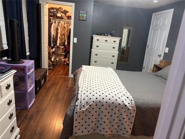 bedroom featuring a closet, a walk in closet, and dark hardwood / wood-style floors