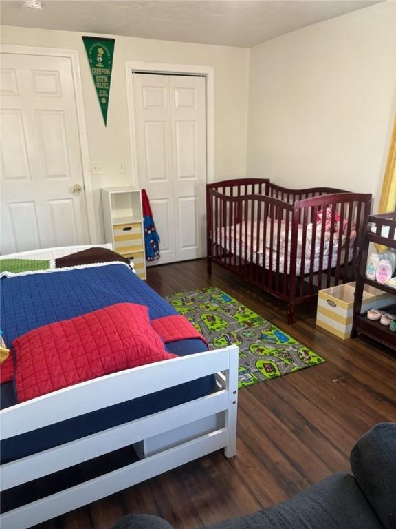 bedroom with dark hardwood / wood-style flooring and a closet