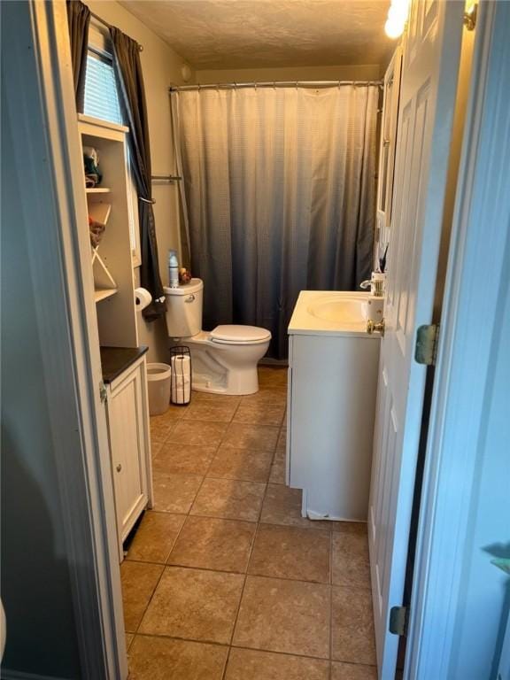 bathroom featuring vanity, toilet, and tile patterned flooring