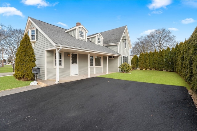 cape cod-style house with a front yard and covered porch