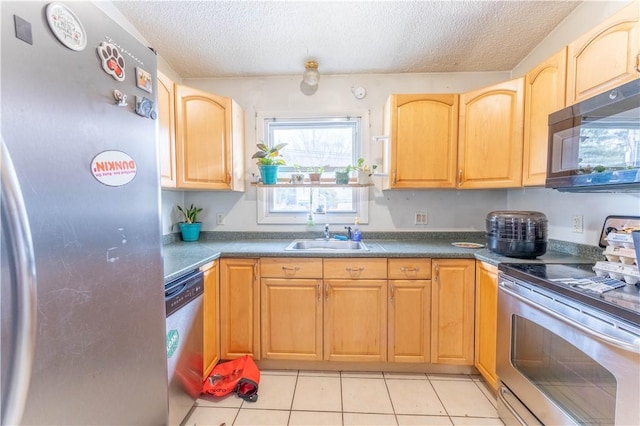 kitchen featuring light tile patterned flooring, appliances with stainless steel finishes, sink, and a textured ceiling