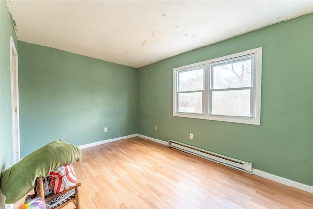 unfurnished room with light wood-type flooring and baseboard heating