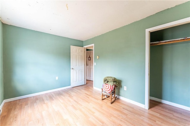 unfurnished bedroom with a closet and light hardwood / wood-style flooring