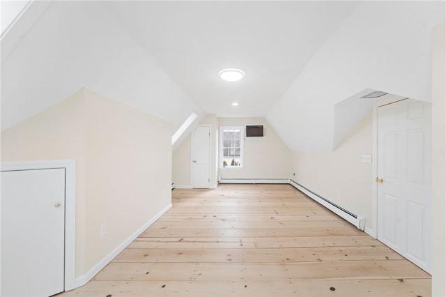 bonus room with lofted ceiling, a baseboard heating unit, and light wood-type flooring