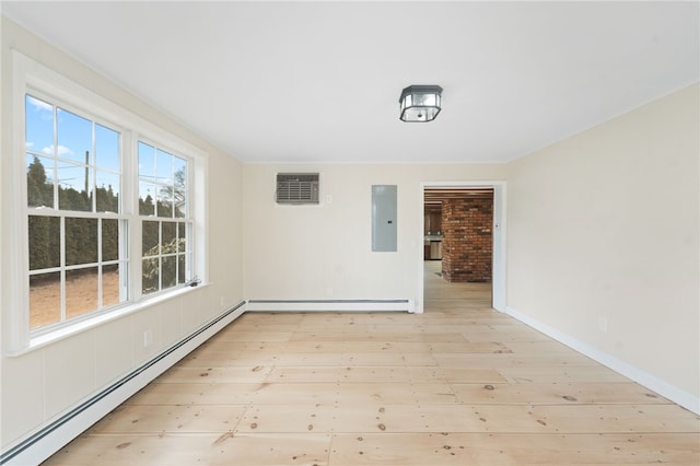 spare room with electric panel, light hardwood / wood-style flooring, and a baseboard heating unit