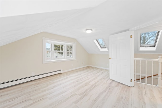 bonus room with a baseboard radiator, lofted ceiling with skylight, and light wood-type flooring