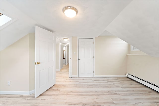 bonus room featuring light wood-type flooring, baseboard heating, and a skylight