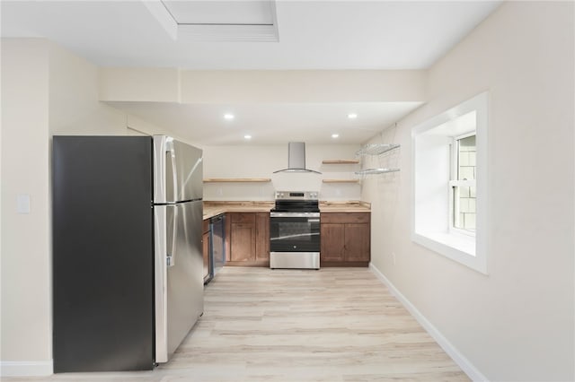 kitchen with light hardwood / wood-style flooring, wall chimney exhaust hood, and appliances with stainless steel finishes