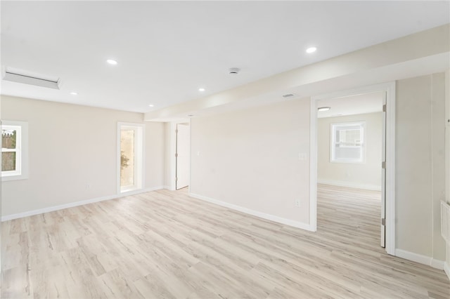 empty room with light hardwood / wood-style flooring and plenty of natural light