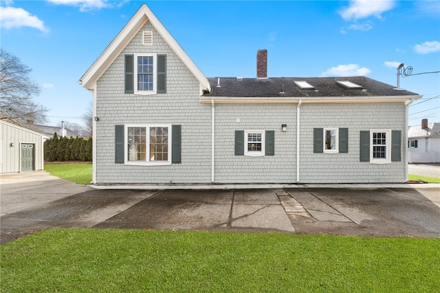 rear view of house featuring a yard