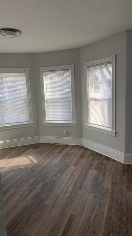 unfurnished dining area featuring dark wood-type flooring and a wealth of natural light