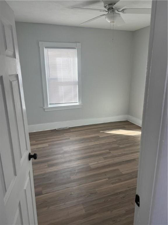 empty room with ceiling fan and dark hardwood / wood-style floors