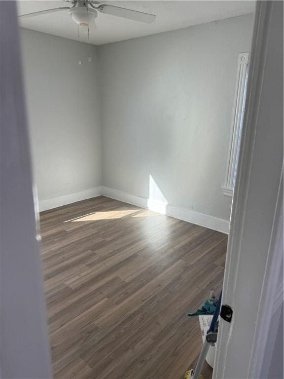 spare room with dark hardwood / wood-style floors and ceiling fan