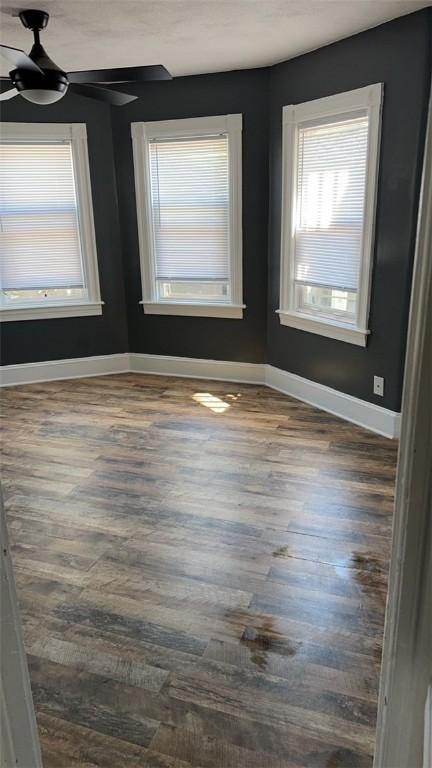 unfurnished room featuring dark hardwood / wood-style flooring and ceiling fan