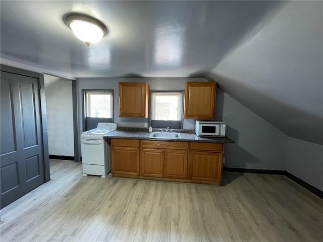 kitchen with lofted ceiling, sink, white appliances, and light hardwood / wood-style floors