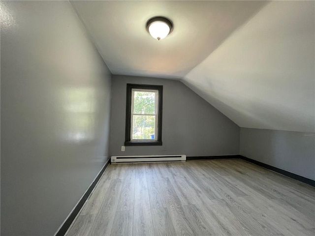 bonus room featuring a baseboard radiator, vaulted ceiling, and light wood-type flooring