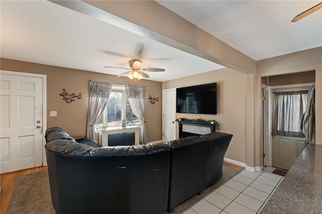 living room with radiator heating unit, ceiling fan, and light tile patterned floors