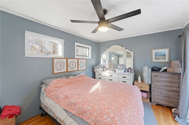 bedroom with crown molding, light hardwood / wood-style flooring, and ceiling fan