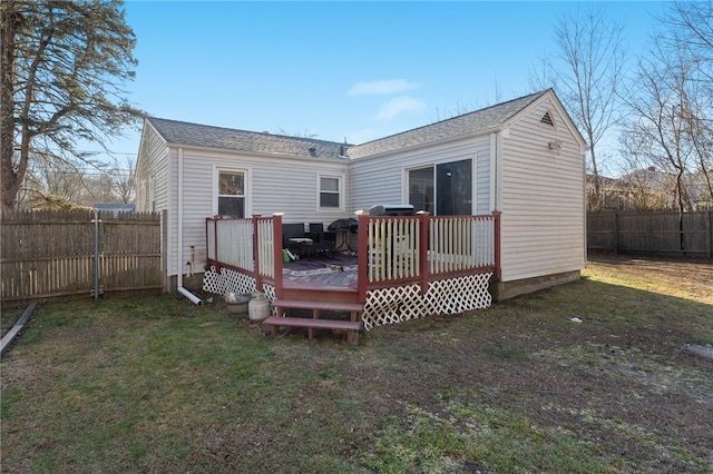 back of house with a wooden deck and a yard