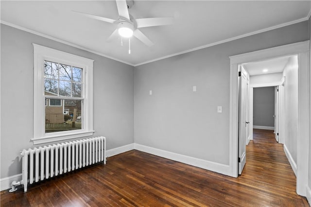 empty room with dark hardwood / wood-style flooring, crown molding, radiator heating unit, and ceiling fan