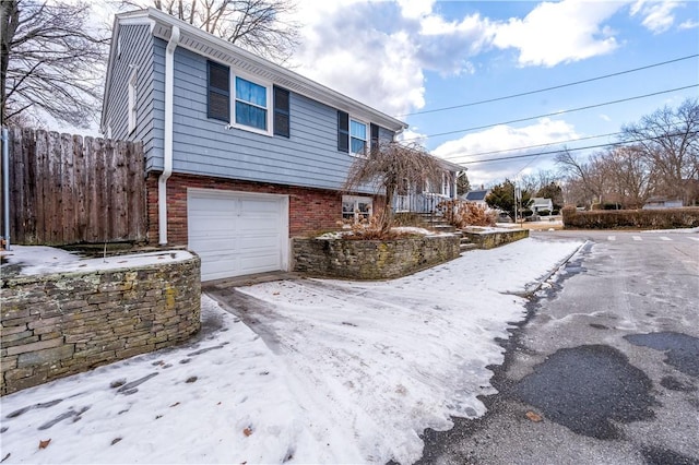 view of snow covered exterior featuring a garage